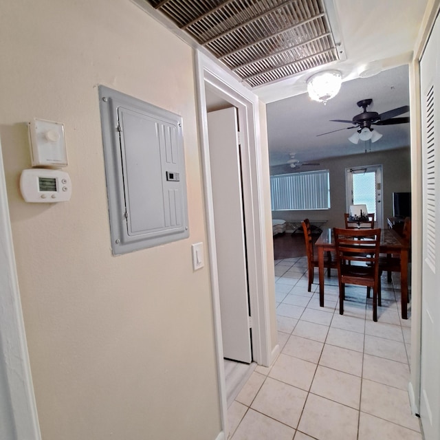 hall with electric panel, light tile patterned floors, and visible vents