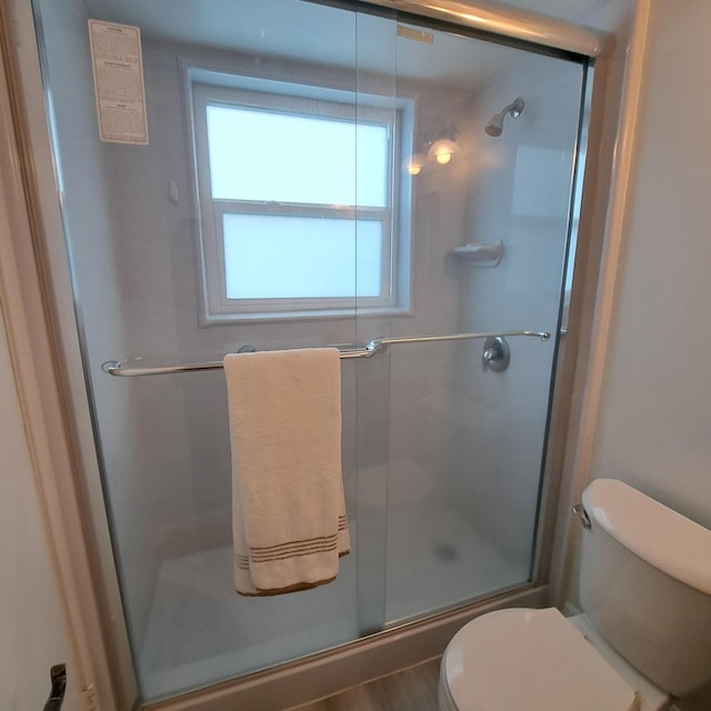 full bathroom featuring a stall shower and toilet