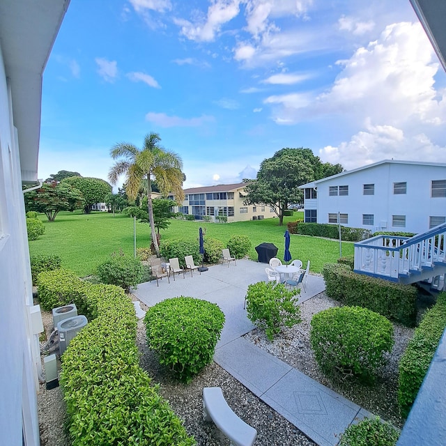 view of property's community with a yard and a patio