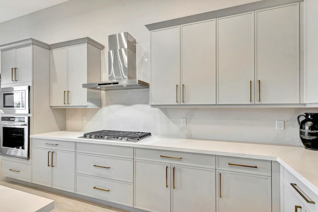 kitchen featuring wall chimney exhaust hood, light hardwood / wood-style flooring, stainless steel appliances, and tasteful backsplash