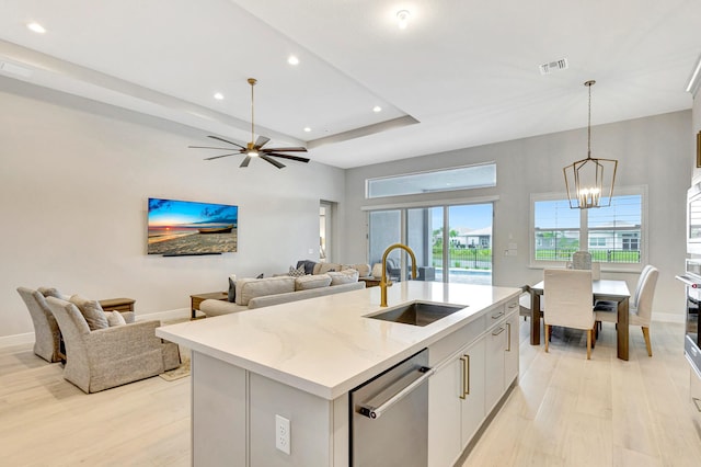 kitchen featuring a kitchen island with sink, white cabinets, ceiling fan with notable chandelier, sink, and appliances with stainless steel finishes