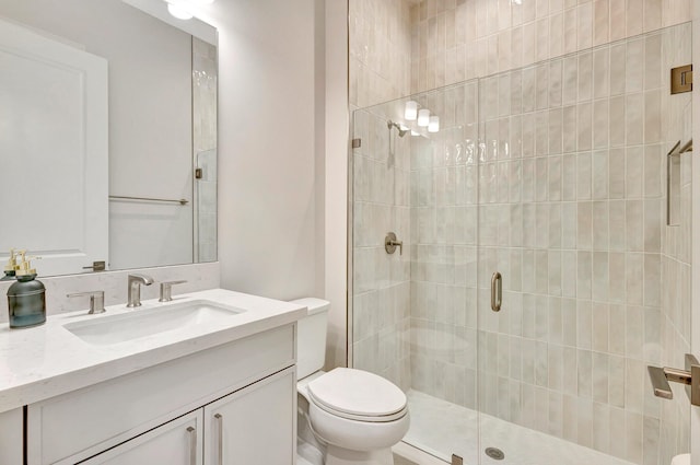 bathroom with vanity, a shower with shower door, and toilet