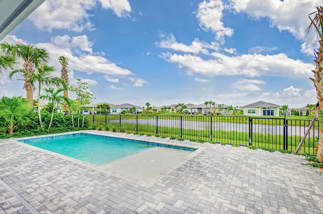 view of pool featuring a water view and a patio