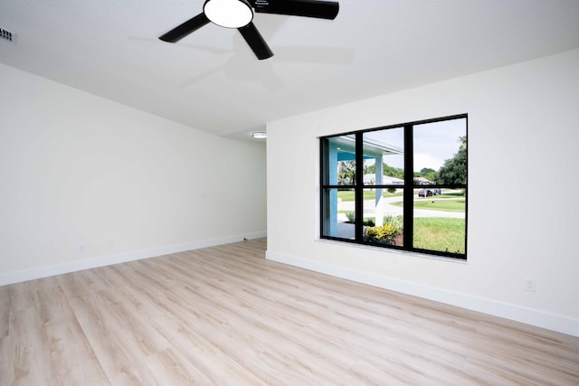 empty room with ceiling fan and light hardwood / wood-style flooring