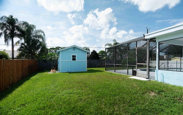 view of yard featuring glass enclosure, a storage shed, a patio, and a fenced in pool