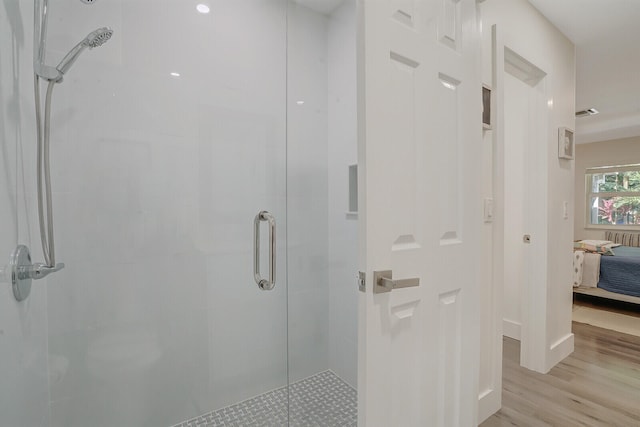 bathroom featuring wood-type flooring and an enclosed shower