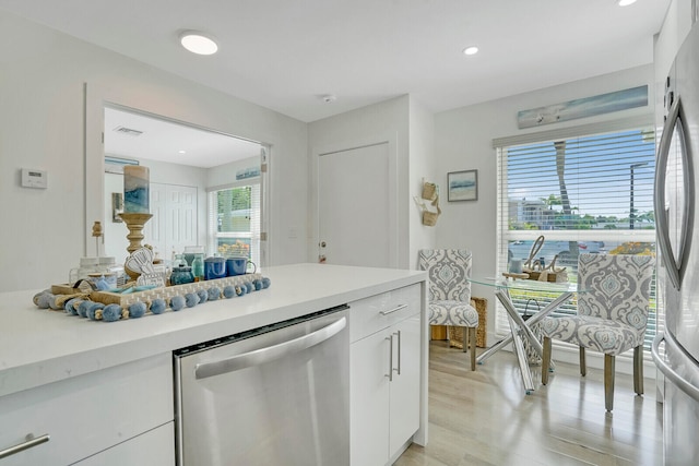 kitchen with light hardwood / wood-style floors, stainless steel appliances, and white cabinets