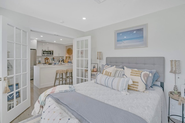 bedroom featuring light hardwood / wood-style flooring and stainless steel fridge