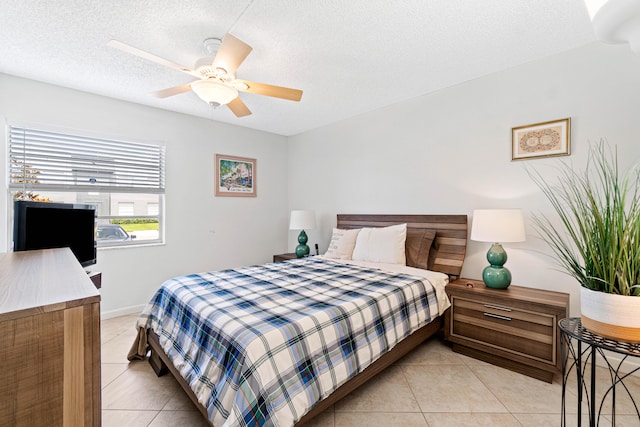 tiled bedroom with ceiling fan and a textured ceiling