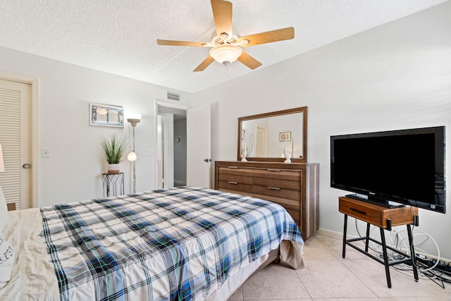 tiled bedroom featuring a textured ceiling and ceiling fan