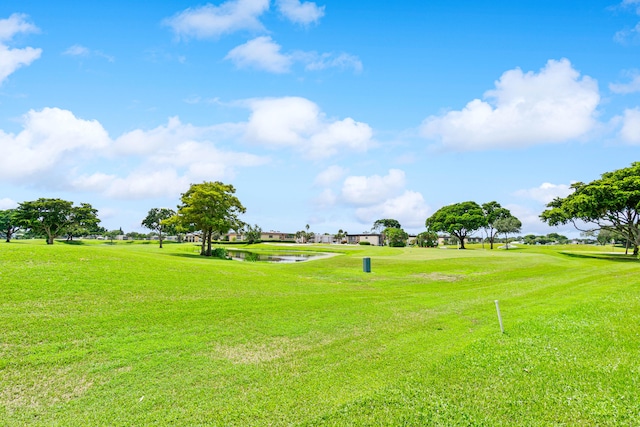 surrounding community with a water view and a yard