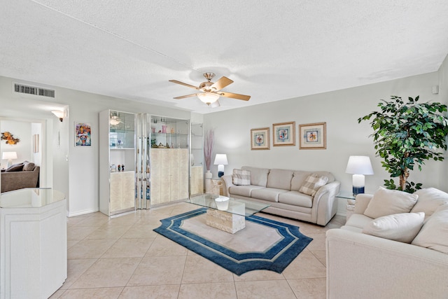 tiled living room featuring ceiling fan and a textured ceiling