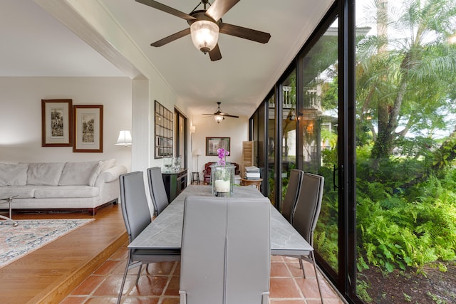 dining space with ceiling fan, light wood-type flooring, and a wall of windows