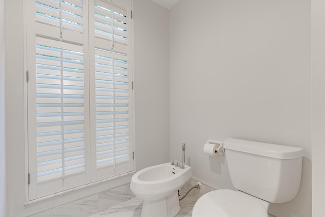 bathroom featuring toilet and a bidet