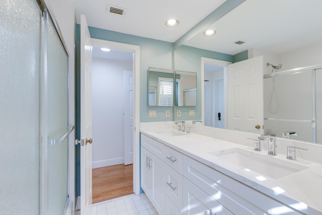 bathroom with hardwood / wood-style floors, an enclosed shower, and vanity