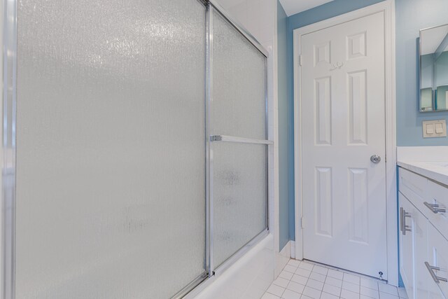 bathroom with tile patterned floors, vanity, and combined bath / shower with glass door