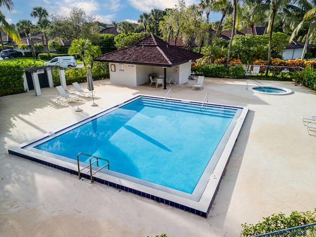 view of swimming pool with a hot tub and a patio area