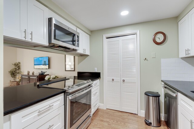 kitchen with light wood-type flooring, stainless steel appliances, and white cabinetry