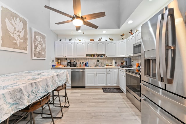 kitchen featuring stainless steel appliances, sink, ceiling fan, and white cabinets