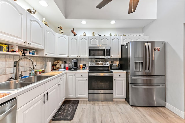 kitchen featuring white cabinets, light wood-type flooring, stainless steel appliances, sink, and ceiling fan