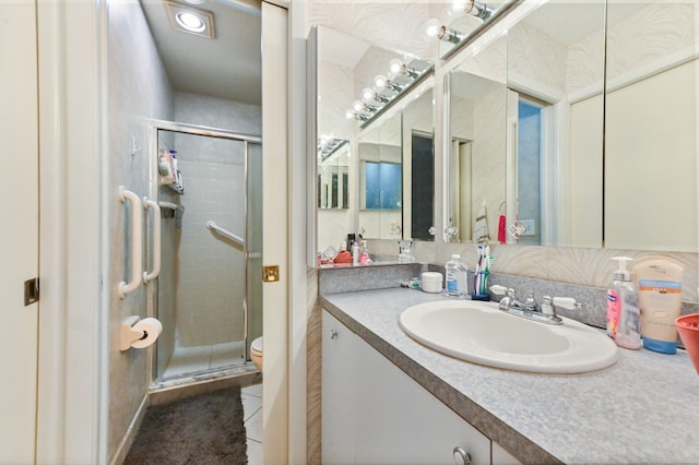 bathroom featuring vanity, toilet, an enclosed shower, and tile patterned flooring