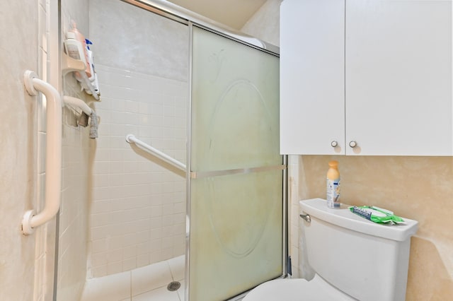 bathroom featuring toilet and an enclosed shower