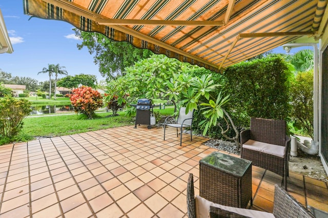 view of patio with grilling area and a water view