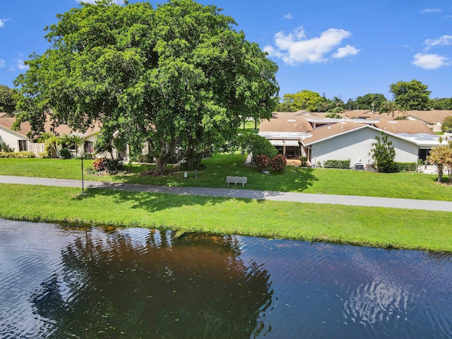 exterior space featuring a lawn and a water view