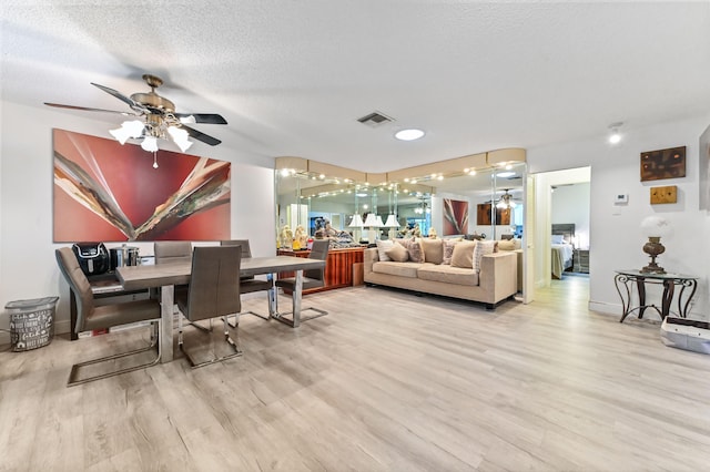 dining area featuring ceiling fan, hardwood / wood-style flooring, and a textured ceiling