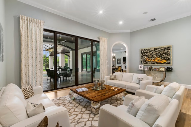 living room with light wood-type flooring and crown molding