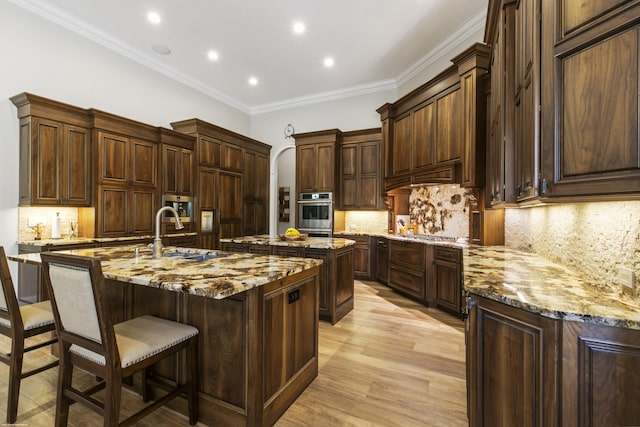 11780 Otter Run, Lake Worth, FL 33449 - kitchen featuring a kitchen bar, tasteful backsplash, a sink, light stone counters, and an island with sink