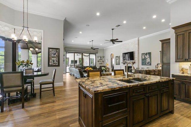 11780 Otter Run, Lake Worth, FL 33449 - kitchen with visible vents, a center island with sink, a sink, ceiling fan with notable chandelier, and recessed lighting