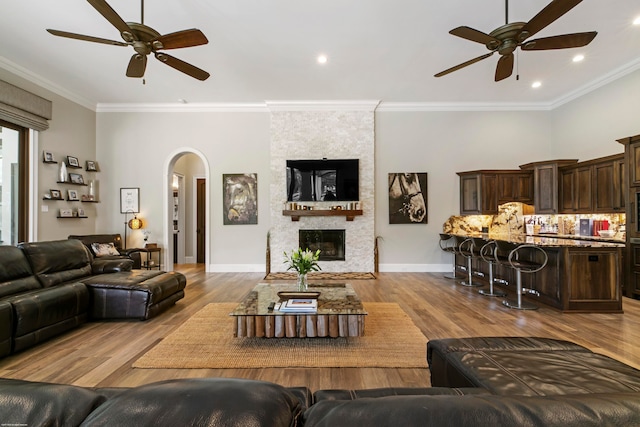 living room with light hardwood / wood-style flooring, ceiling fan, and ornamental molding