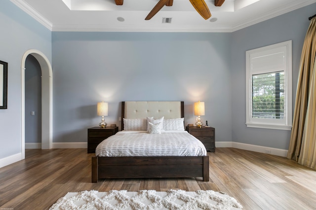 bedroom with ceiling fan, crown molding, and hardwood / wood-style floors