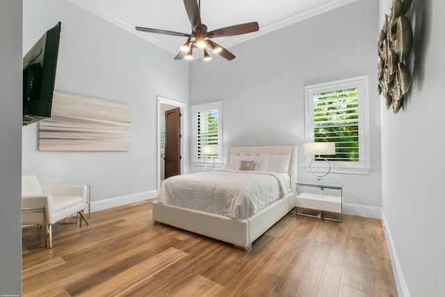 bedroom with ornamental molding, wood-type flooring, and ceiling fan