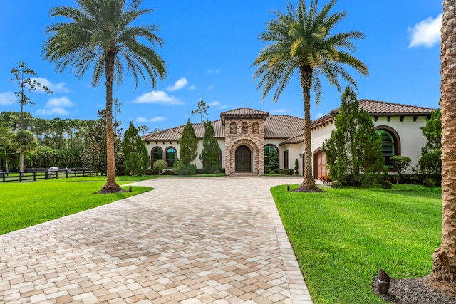 11780 Otter Run, Lake Worth, FL 33449 - mediterranean / spanish-style house featuring a front yard, a garage, fence, curved driveway, and stucco siding