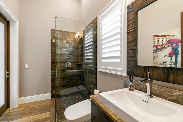 bathroom featuring vanity, toilet, a shower with door, and hardwood / wood-style flooring