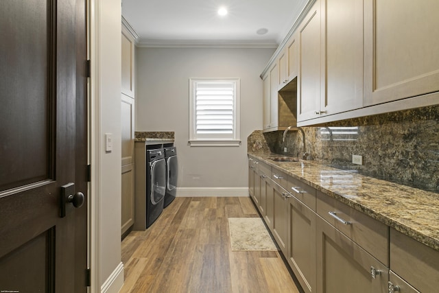 11780 Otter Run, Lake Worth, FL 33449 - kitchen with decorative backsplash, washing machine and dryer, a sink, light wood-style floors, and ornamental molding