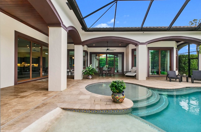 view of swimming pool with ceiling fan, a patio, and a lanai