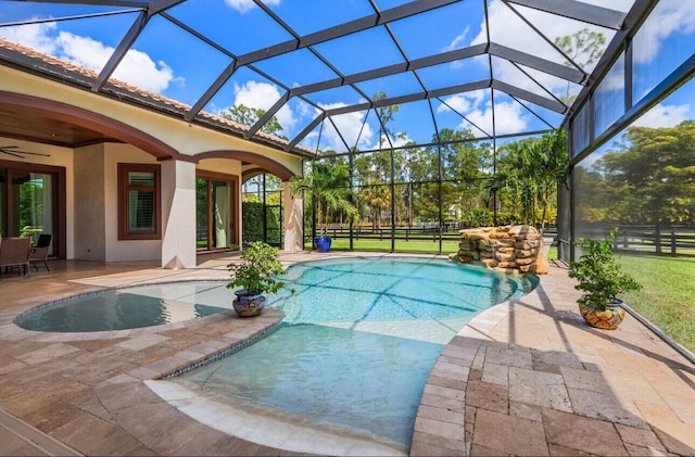 view of swimming pool featuring a lanai, ceiling fan, and a patio area