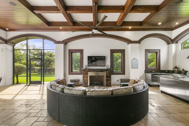 11780 Otter Run, Lake Worth, FL 33449 - living room with a healthy amount of sunlight, coffered ceiling, a stone fireplace, and stone tile floors