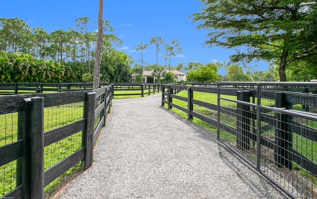 view of gate featuring a lawn and a rural view