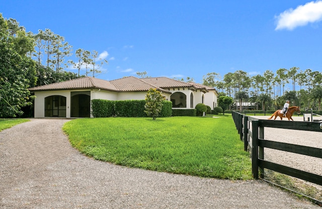 11780 Otter Run, Lake Worth, FL 33449 - mediterranean / spanish-style home with a tiled roof, driveway, fence, a front lawn, and stucco siding