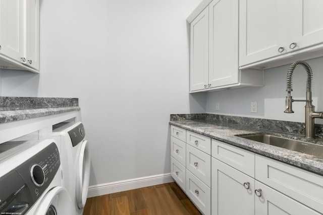 laundry area featuring washer and clothes dryer, cabinets, sink, and dark hardwood / wood-style flooring