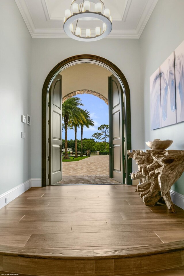 11780 Otter Run, Lake Worth, FL 33449 - interior space with an inviting chandelier, arched walkways, wood finished floors, and ornamental molding