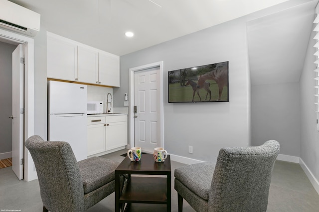 interior space with vaulted ceiling, sink, and a wall mounted AC