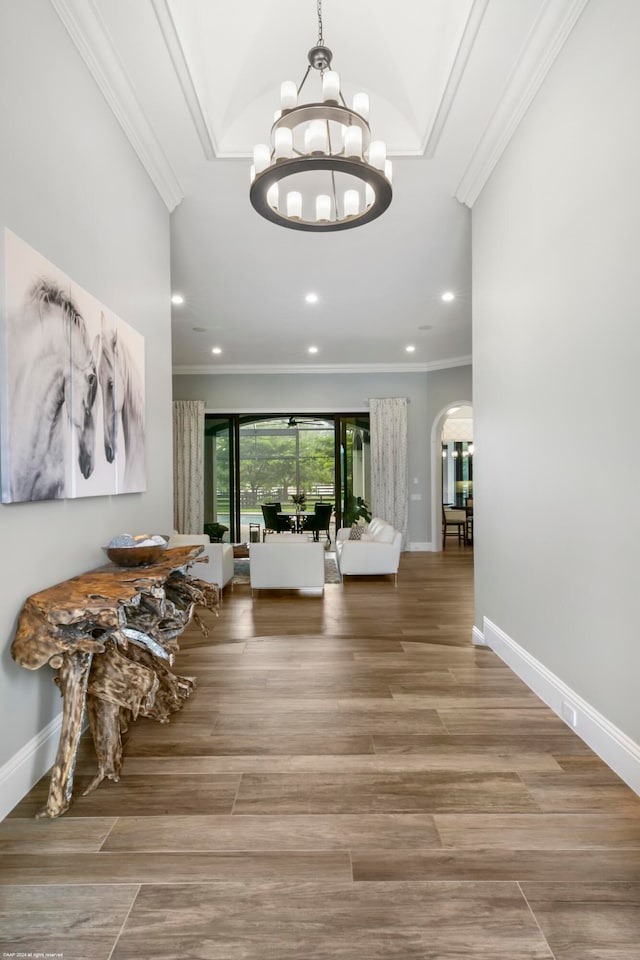 hallway featuring a notable chandelier, crown molding, and hardwood / wood-style flooring