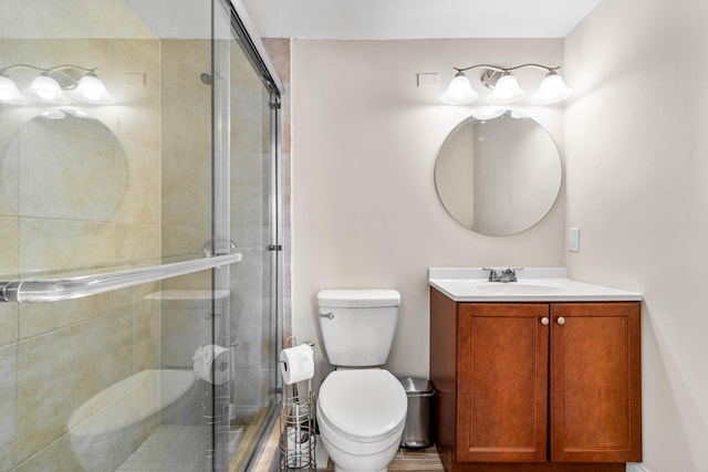 bathroom with vanity, toilet, and an enclosed shower