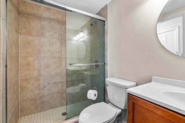 bathroom with vanity, toilet, and a shower with shower door