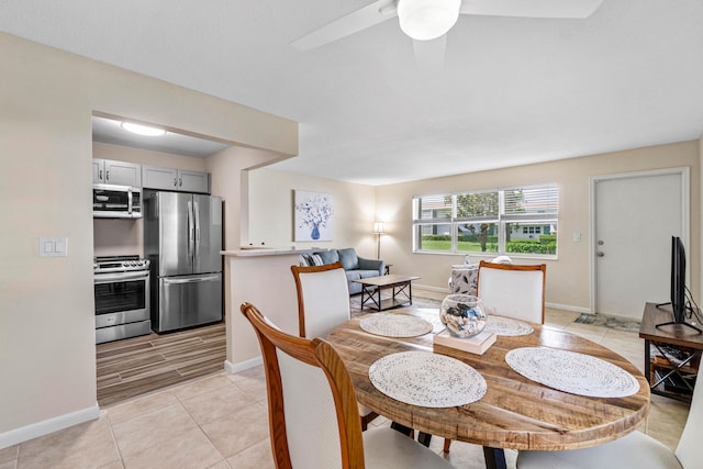 dining space with ceiling fan and light tile patterned flooring